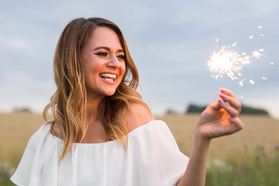 Aesthetic-Vaginal-Enhancement-Clinic A beautiful woman in a field holding a sparkler. Get aesthetic vaginal enhancement surgery from Scott Gulinson, MD, FACOG in Phoenix.