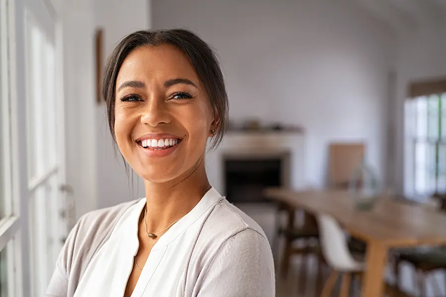 BioTE-Bioidentical-Hormone-Pellets-for-Women-Clinic A middle-aged woman smiling in her open living area. Schedule a consultation for BioTE Bioidentical Hormone Pellets for Women from Scott Gulinson, MD, FACOG in Phoenix.