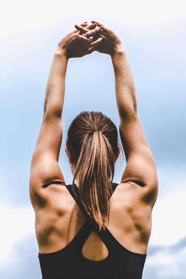 GLP-1-Weight-Loss-Injections-Treatment A toned woman seen from behind stretching her arms into the air. Get GLP-1 Weight Loss Injections from Scott Gulinson, MD, FACOG in Phoenix.