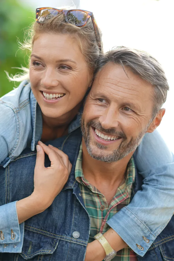 Hypogonadism-Treatment A couple in denim jackets embrace playfully outdoors. Get hypogonadism treatment from Scott Gulinson, MD, FACOG in Phoenix.