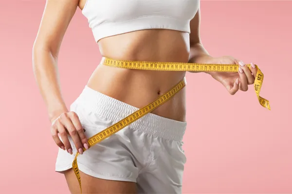 Physician-Assisted-Weight-Loss-Clinic A woman holds a measuring tape around her waist. Schedule a consultation for personalized, physician-assisted weight loss plans from Scott Gulinson, MD, FACOG in Phoenix.