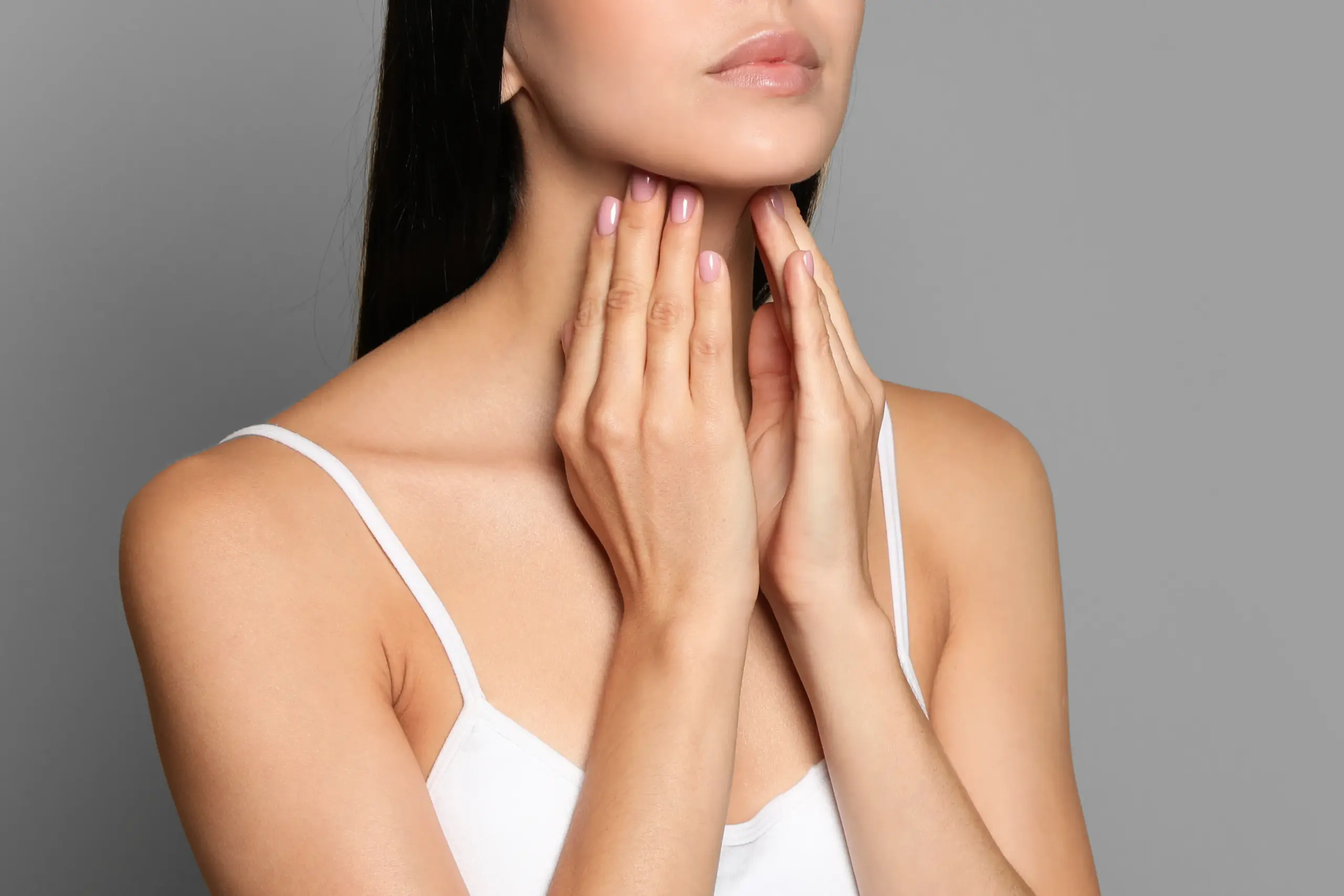 Thyroid-Doctor A woman in a white tank top touches her neck looking for signs of thyroid disorder. Get help for thyroid disorders from Scott Gulinson, MD, FACOG in Phoenix.